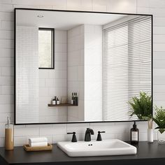 a bathroom sink sitting under a large mirror next to a window with blinds on it