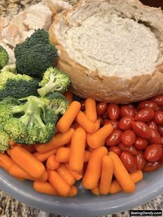 broccoli, carrots, tomatoes, bread and other food items on a plate