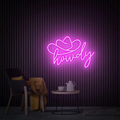 a purple neon sign that says happily next to a table with a teapot on it