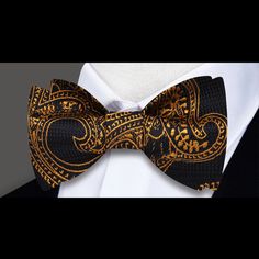 Unveiling Opulence: The Black and Gold Paisley Pattern Silk Bow Tie In the realm of sophisticated menswear, there exists an accessory that stands out as the epitome of refined elegance – the Black and Gold Paisley Pattern Silk Bow Tie. Imbued with a timeless paisley motif, this bow tie isn't just an accessory; it's a symbol of opulence and style that transcends fashion trends. Design Extravaganza: Black and Gold Paisley Pattern Prepare to be captivated by the intricate paisley pattern adorning t Dapper Gold Bow Tie For Formal Occasions, Gold Dapper Bow Tie For Formal Occasions, Gold Bow Tie For Formal Occasions, Classic Gold Bow Tie For Business, Gold Bow Tie For Business, Gold Classic Bow Tie For Business, Luxury Gold Tie For Formal Occasions, Elegant Gold Bow Tie For Formal Occasions, Elegant Gold Ties For Party