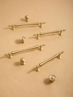 six pairs of gold door handles and knobs on a beige background with space for text