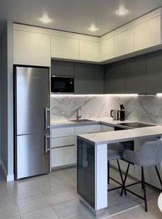 a modern kitchen with marble counter tops and stainless steel appliances