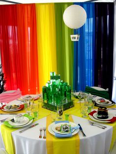 the table is set with colorful plates and place settings