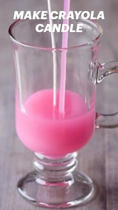 a pink drink in a glass cup with two straws sticking out of the top