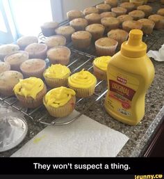 cupcakes and muffins are on the counter next to a bottle of orange juice