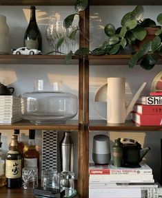 the shelves are filled with bottles, glasses and other items on them as well as books