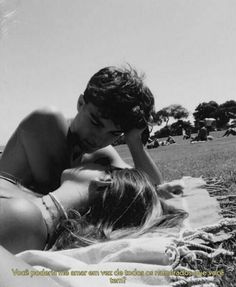 two women laying on the grass in bikinis and one is touching her head with her hand