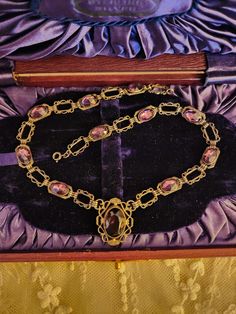 This listing is for an antique sterling silver and purple Amethyst paste stones necklace. The necklace is 15" long and the little central pendant drop is 1" long x 3/4" wide. There are 11 total Amethyst paste stones, with the cental stone being the largest. There is a flea bite on the central stone above the top facets but is very hard to see without magnification. This is a preloved, antique necklace and will show signs of wear. There may be scratches ,flea bites as mentioned above and abrasions to this piece.My items are sold as found and I do my best to describe ,what you will be receiving when you make a purchase. Wear is commensurate with age. This piece tests as silver. The 10 side stones are closed back and may have foiling to them but I cannot see the backs so it is my best guess t Victorian Jeweled Necklaces For Formal Occasions, Antique Silver Jeweled Necklace, Antique Jeweled Silver Necklace, Antique Silver Jeweled Necklaces, Vintage Oval Jeweled Necklaces, Vintage Oval Jeweled Necklace, Vintage Jeweled Oval Necklace, Victorian Jeweled Pendant Necklace, Purple Jeweled Necklace For Formal Occasions