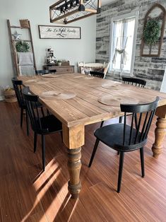 a wooden table with black chairs in a room