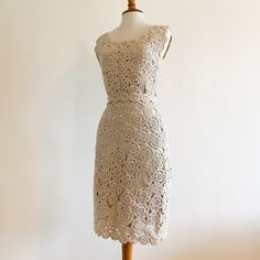 A true rare beauty - vintage 1950s/1960s hand crocheted wool wiggle dress from Capriel labeled an "original import", 100% all wool, hand made in Italy. The crochet has a floral motif and the yarn is a natural color wool with a thinner shinier thread worked in that gives it a very subtle almost metallic effect which is hard to capture in the photos. Has its own crocheted belt to enhance that wiggle silhouette. Fully lined. Very nice condition with a few areas of discoloration to the crochet as sh Elegant Handmade Fitted Dresses, Beige Fitted Crochet Dress Knee-length, Beige Fitted Knee-length Crochet Dress, Vintage Fitted Crochet Dress For Spring, Fitted Cream Crochet Lace Dress, Handmade Fitted Vintage Dress, Fitted Vintage Lace Crochet Dress, Fitted Vintage Crochet Lace Dress, Fitted Cream Crochet Dress