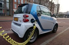 an electric car plugged in to a charger on the side of the road