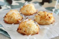 four coconut cookies sitting on top of a piece of paper