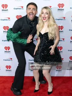 a man and woman posing on the red carpet