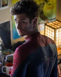 a man in a spider - man suit is looking at the camera