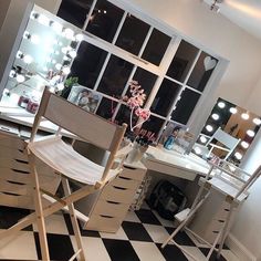 a chair sitting on top of a checkered floor in front of a desk with a mirror