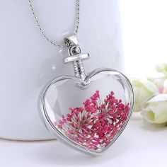 Enjoy the blooms year round with this heart-shaped pendant necklace showcasing pressed flowers set in resin and strung from a silvertone chain. Chain: 23.62'' L Pendant: 1.42'' W x 1.65'' L Lobster claw clasp Silvertone copper / pressed flower / resin Valentine's Day Flower Pendant Necklace Keepsake, Valentine's Day Keepsake Necklace With Flower Pendant, Heart-shaped Silver Jewelry With Pressed Flowers, Silver Heart Jewelry With Pressed Flowers, Silver Heart-shaped Jewelry With Pressed Flowers, White Heart-shaped Jewelry With Pressed Flowers, White Heart Jewelry With Pressed Flowers, Heart-shaped Necklace With Pressed Flowers For Mother's Day, Mother's Day Heart Pendant Necklace With Pressed Flowers