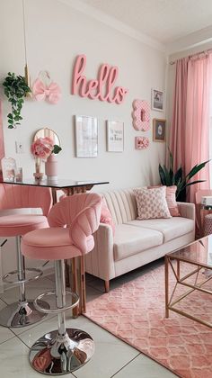 a living room filled with pink furniture and decor on the wall above a glass top table