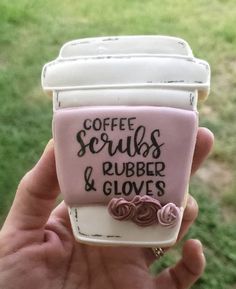 someone is holding up a cupcake shaped like a coffee mug with the words coffee scrubs, rubber and gloves on it