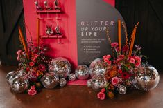 silver vases with flowers and candles in front of a sign that says glitter up your life