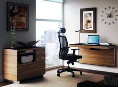 an office with a desk, chair and clock on the wall in front of it