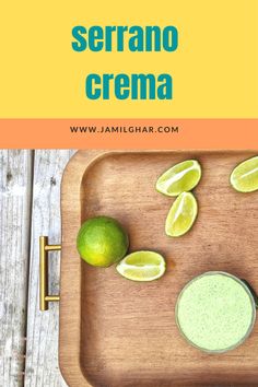 a wooden tray topped with limes next to a green smoothie and a spoon