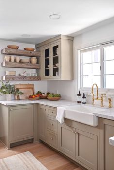 a kitchen filled with lots of counter top space and wooden shelves on the wall above it