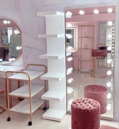 the inside of a beauty salon with stools, mirrors and lights on the walls