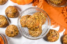 several balls of food sitting on top of a table next to oranges and pumpkins