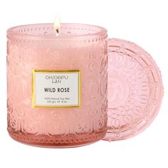 a pink glass candle with a label on the front and side that says wild rose