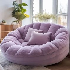 a purple bean bag chair sitting on top of a white rug next to a window