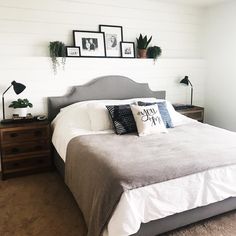 a bed sitting in a bedroom next to two pictures hanging on the wall above it