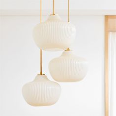 three white lamps hanging from a ceiling in a room