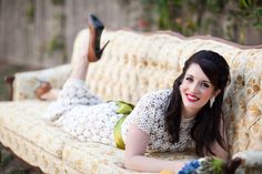 a beautiful woman laying on top of a couch