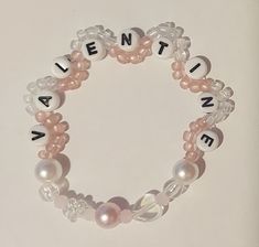 a beaded bracelet with words written in white and pink beads that spell out the word alive