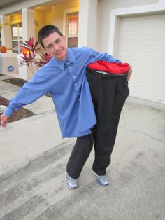 a man in blue shirt and black pants holding up a red bag