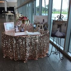 a table with pictures and other items on it in front of large glass windows at an event