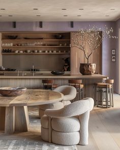 a kitchen with an oval table surrounded by chairs