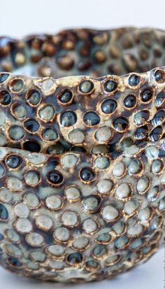 a close up of a bowl on a white surface with holes in the bottom and sides