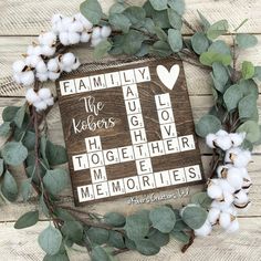 a cross made out of scrabbles and cotton on top of a wooden board