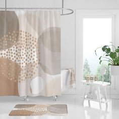 a bathroom with a shower curtain, rug and potted plant on the floor in front of it