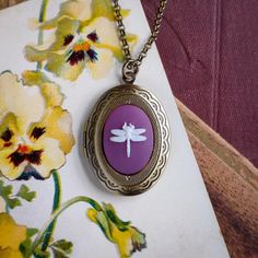 a necklace with a purple dragonfly on it