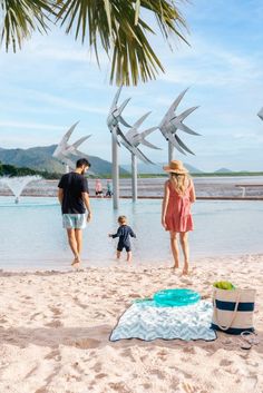 people are walking on the beach near some water