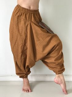 "These super soft rayon baggy unisex harem pants have the \"flow\", perfect of yoga or just a cool strolling. Comfort and character are what these pants are all about. They have the traditional sarong look & feel but a lot more practical when it comes to activity like yoga. As a bonus, they are convertible! Just pull them up and you get yourself a cute jumpsuit in a flash. Together with elastic cuff legs, you can wear them short or long. The pants have smock waist (wide bang elastic) with no Casual Harem Parachute Pants For Yoga, Loosely Fitted Cotton Harem Pants For Meditation, Cotton Hippie Harem Pants For Meditation, Hippie Cotton Harem Pants For Meditation, Baggy Cotton Harem Yoga Pants, Baggy Harem Cotton Yoga Pants, Loose-fit Cotton Harem Yoga Pants, Baggy Brown Harem Pants With Elastic Waistband, Meditation Harem Bottoms With Elastic Waistband