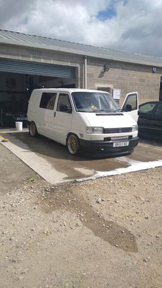 a white van parked in front of a garage