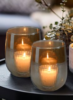 three lit candles sitting on top of a table