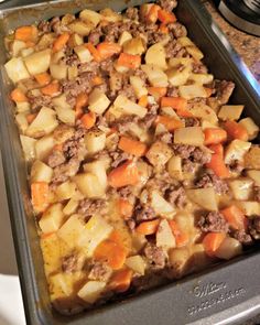 a pan filled with meat and potatoes on top of a stove