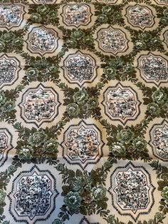 an intricately designed fabric with green leaves on it