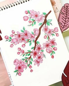 an open notebook with pink flowers and leaves on it