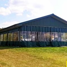 a large green building sitting on top of a lush green field