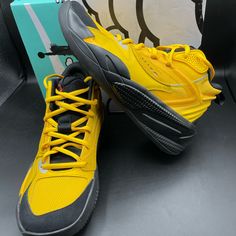 a pair of yellow and black shoes sitting on top of a box